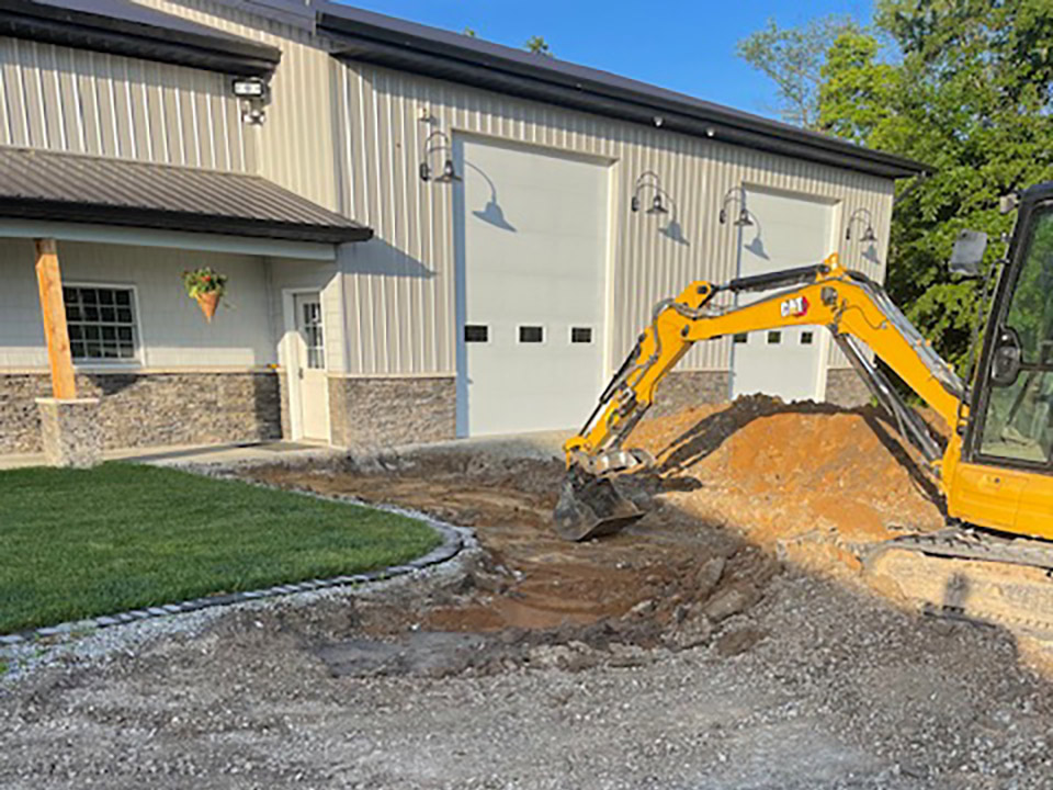 a backhoe from 6 1 1 Boring and Excavating working near a building
